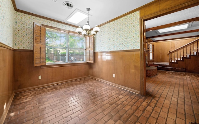 1101 Canada St, Jacksonville, TX 75766 - unfurnished dining area featuring a wainscoted wall, brick flooring, a chandelier, wallpapered walls, and crown molding
