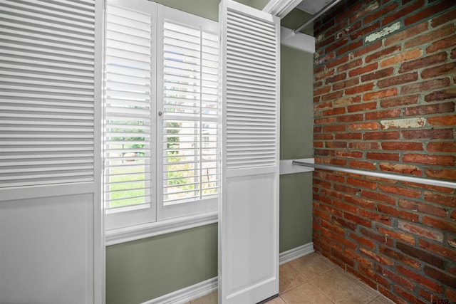 1101 Canada St, Jacksonville, TX 75766 - doorway to outside with tile patterned flooring, baseboards, and brick wall