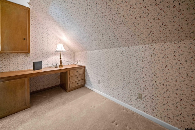1101 Canada St, Jacksonville, TX 75766 - unfurnished office with wallpapered walls, vaulted ceiling, light carpet, and built in study area