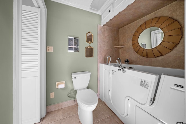 1101 Canada St, Jacksonville, TX 75766 - bathroom with tile patterned flooring, toilet, baseboards, and washer / clothes dryer