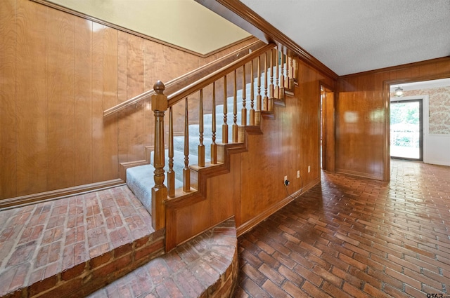 1101 Canada St, Jacksonville, TX 75766 - stairway featuring brick floors, wood walls, and a textured ceiling