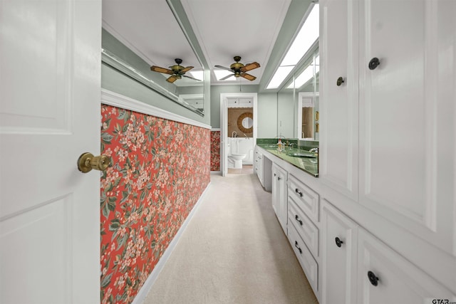 1101 Canada St, Jacksonville, TX 75766 - bathroom with wallpapered walls, vanity, toilet, and a skylight