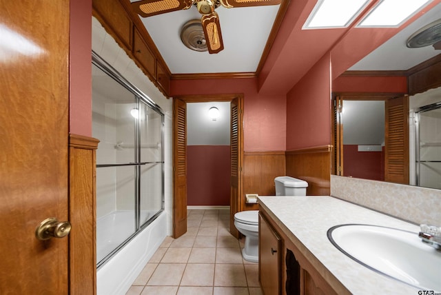 1101 Canada St, Jacksonville, TX 75766 - bathroom featuring toilet, wainscoting, crown molding, ceiling fan, and tile patterned flooring