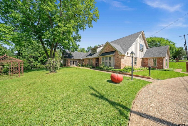 1101 Canada St, Jacksonville, TX 75766 - view of front of house featuring brick siding, board and batten siding, a front lawn, and a shingled roof