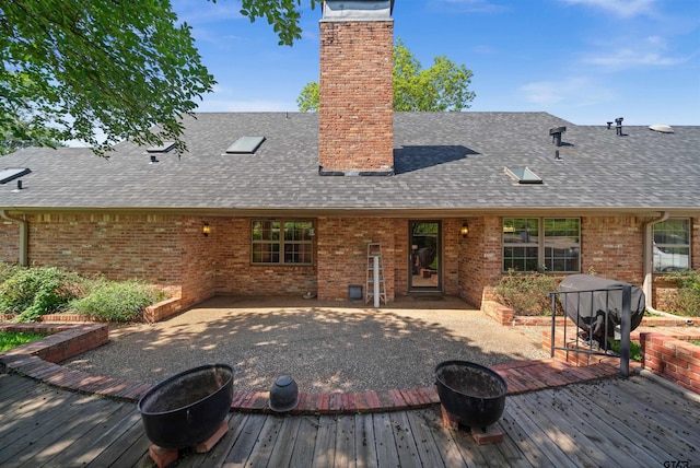 1101 Canada St, Jacksonville, TX 75766 - back of property with a fire pit, a shingled roof, and a wooden deck