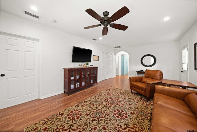 living room with light hardwood / wood-style floors and ceiling fan