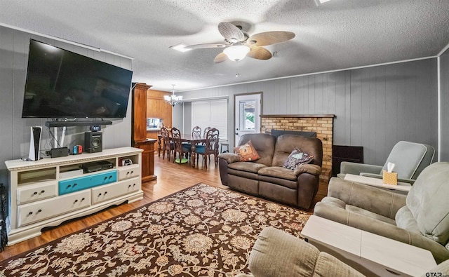 10236 County Road 2253, Tyler, TX 75707 - living room with wood finished floors, a ceiling fan, a chandelier, and a textured ceiling