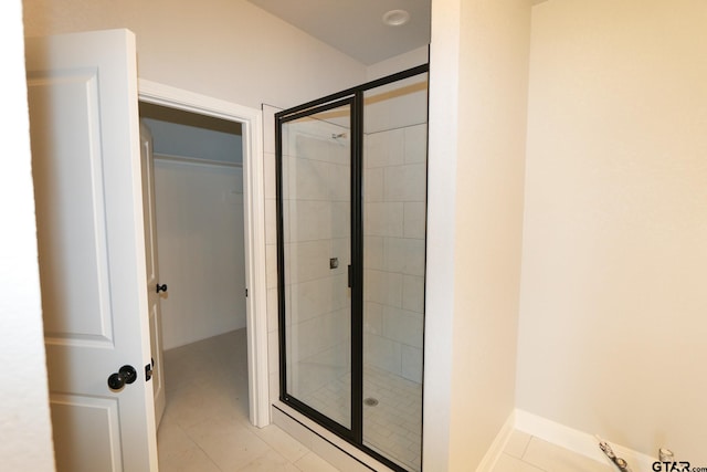 bathroom with an enclosed shower and tile patterned flooring