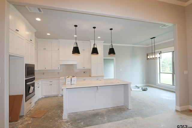 kitchen featuring stainless steel appliances, white cabinetry, a large island, and crown molding