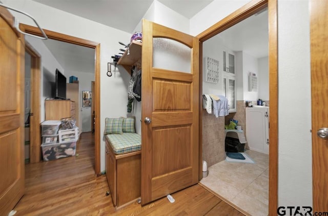 interior space featuring vanity, wood finished floors, and tile walls