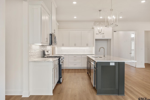 kitchen featuring a center island with sink, white cabinets, sink, and stainless steel gas range