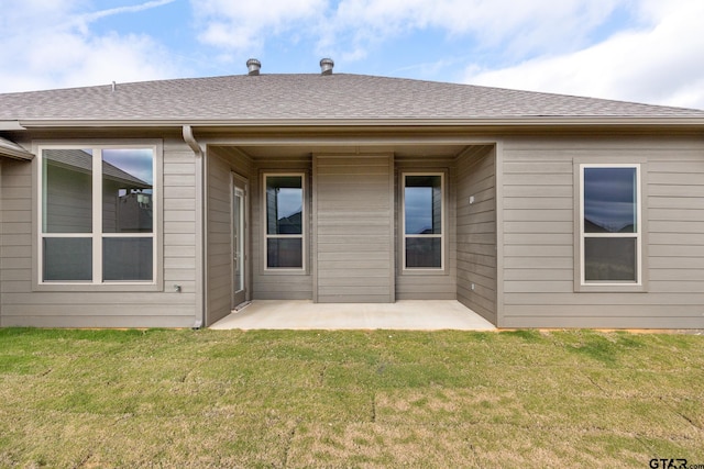 back of house with a lawn and a patio area