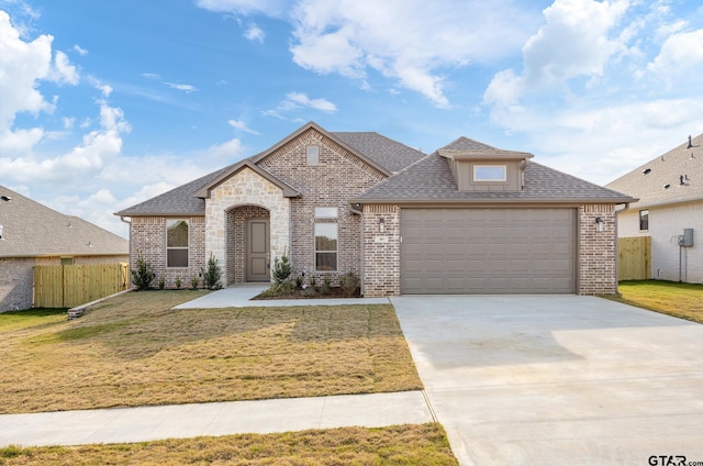 french provincial home with a front yard and a garage