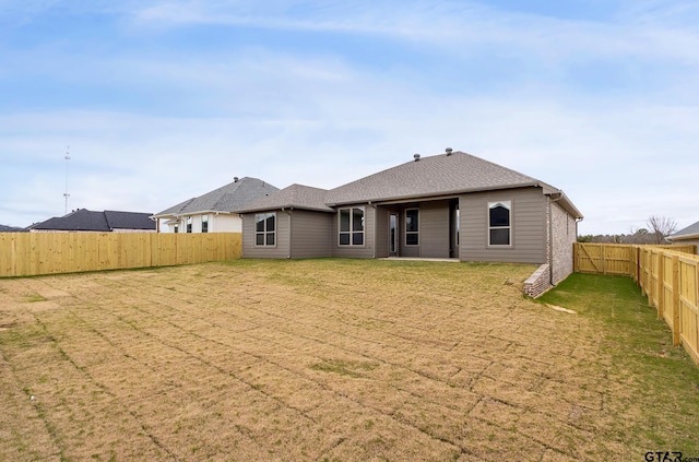 rear view of house featuring a yard