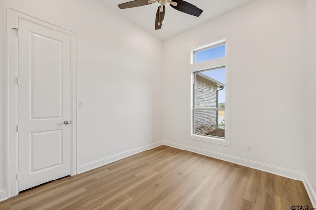 empty room with ceiling fan and light hardwood / wood-style flooring