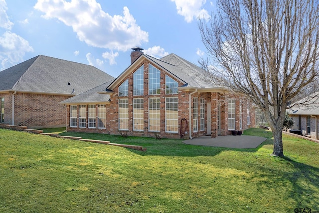 rear view of property featuring a yard and a patio