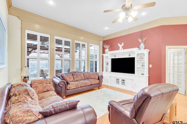 living area with a wealth of natural light, a ceiling fan, light wood finished floors, and ornamental molding