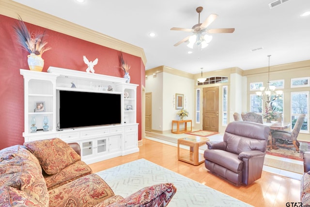 living room with recessed lighting, ceiling fan with notable chandelier, crown molding, and light wood-type flooring