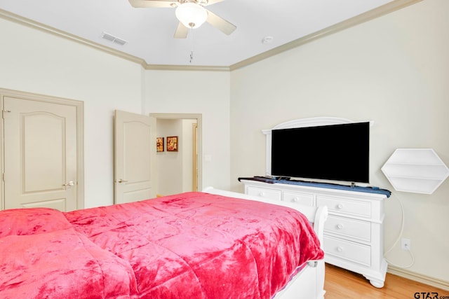 bedroom featuring visible vents, ceiling fan, light wood-style floors, and ornamental molding