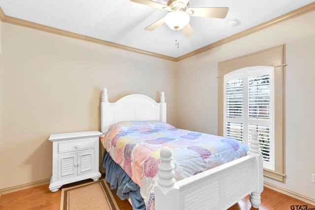 bedroom featuring crown molding, a ceiling fan, light wood-type flooring, and baseboards