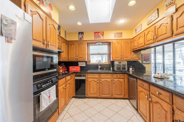 1511 Dolly Ln, Hideaway, TX 75771 - kitchen with stainless steel appliances, backsplash, recessed lighting, brown cabinets, and light tile patterned floors