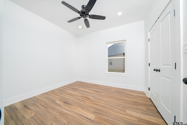 empty room featuring light wood finished floors, recessed lighting, and baseboards