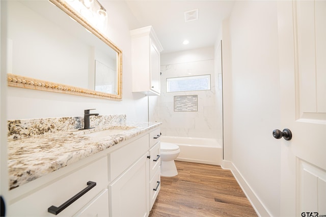 full bath featuring baseboards, toilet, wood finished floors, vanity, and shower / bathing tub combination