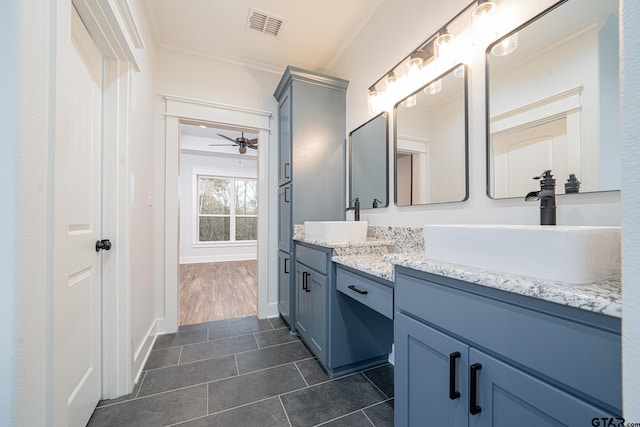 bathroom with double vanity, a sink, visible vents, and crown molding