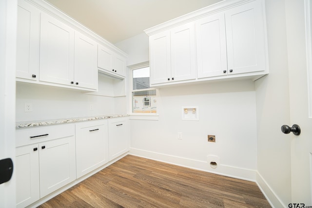 washroom featuring cabinet space, baseboards, dark wood-style floors, hookup for a washing machine, and hookup for an electric dryer