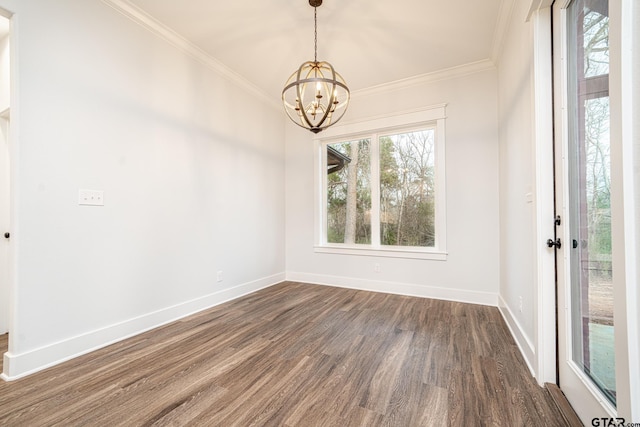 unfurnished dining area featuring dark wood finished floors, a notable chandelier, crown molding, and baseboards