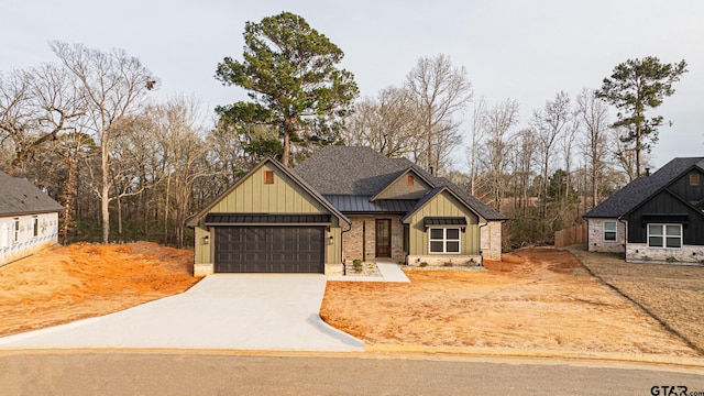 view of front of property featuring metal roof, a standing seam roof, board and batten siding, and driveway