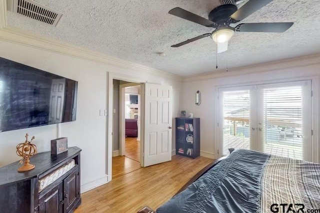 bedroom with access to exterior, french doors, visible vents, ornamental molding, and light wood-type flooring