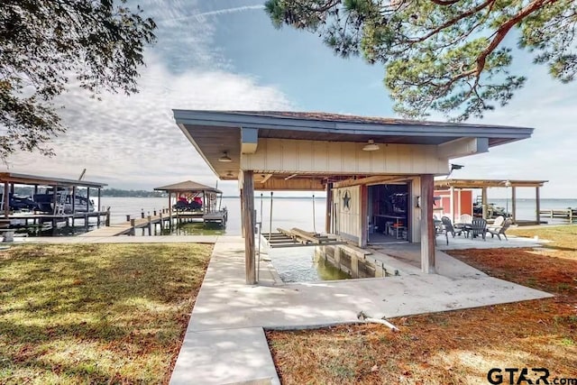 view of dock featuring a water view, a yard, and boat lift