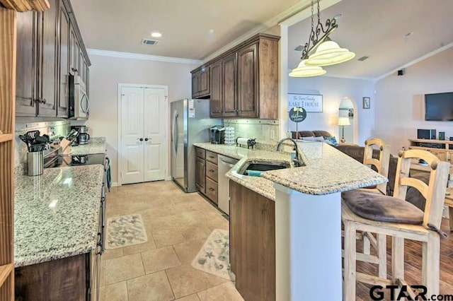 kitchen with light stone countertops, sink, decorative backsplash, and appliances with stainless steel finishes