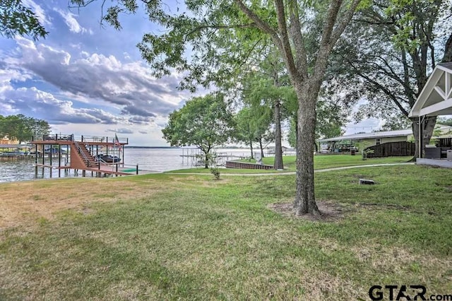 view of yard featuring a water view and a boat dock