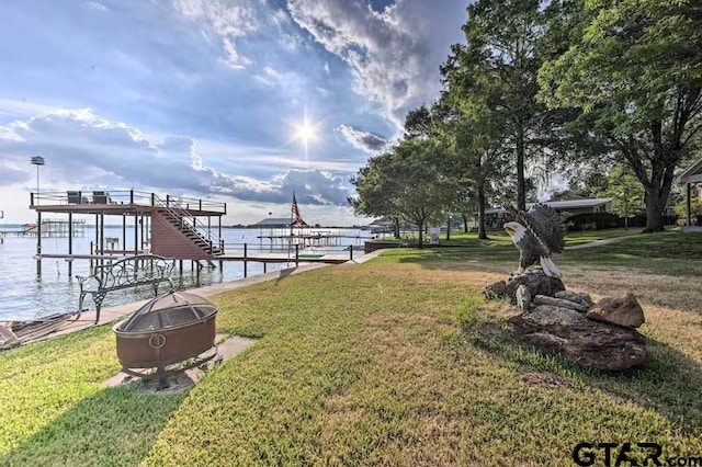 view of dock featuring a water view and a yard