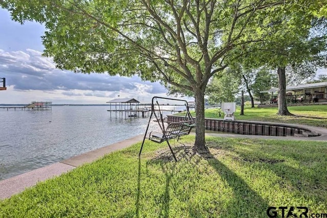 view of dock with a water view and a yard