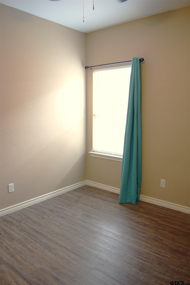 unfurnished room with ceiling fan and dark hardwood / wood-style floors