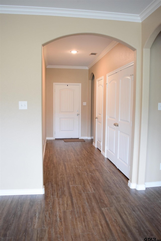 corridor with dark wood-type flooring and ornamental molding