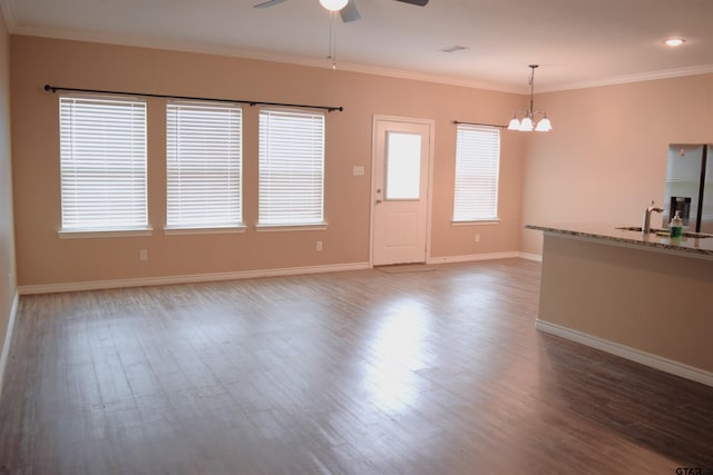 unfurnished living room with ceiling fan with notable chandelier, dark hardwood / wood-style floors, crown molding, and sink