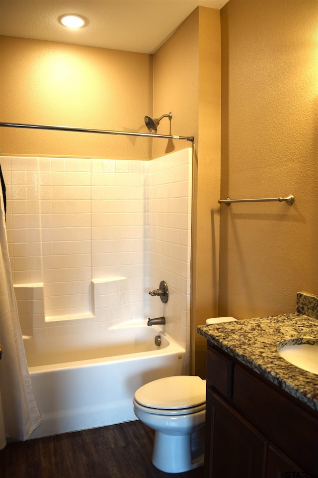 full bathroom with toilet, hardwood / wood-style floors, a textured ceiling, vanity, and shower / tub combo