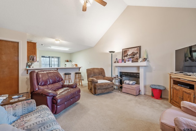 living area with high vaulted ceiling, light carpet, a fireplace, and a ceiling fan