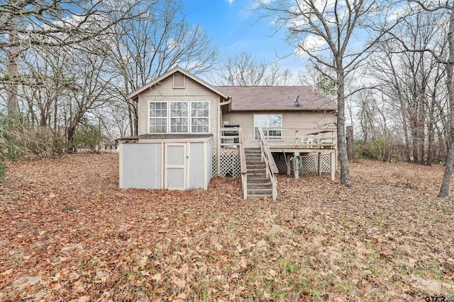 back of property featuring stairs and a deck