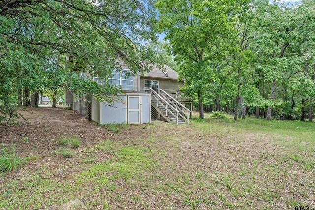 207 Pagosa Ln, Holly Lake Ranch, TX 75765 - view of yard featuring stairway and a wooden deck