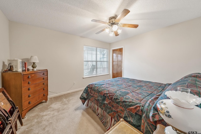 bedroom featuring baseboards, a ceiling fan, a textured ceiling, and light colored carpet