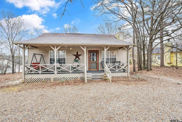 view of front of house with a chimney and a porch