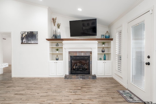 unfurnished living room with light hardwood / wood-style floors, a tile fireplace, and ornamental molding