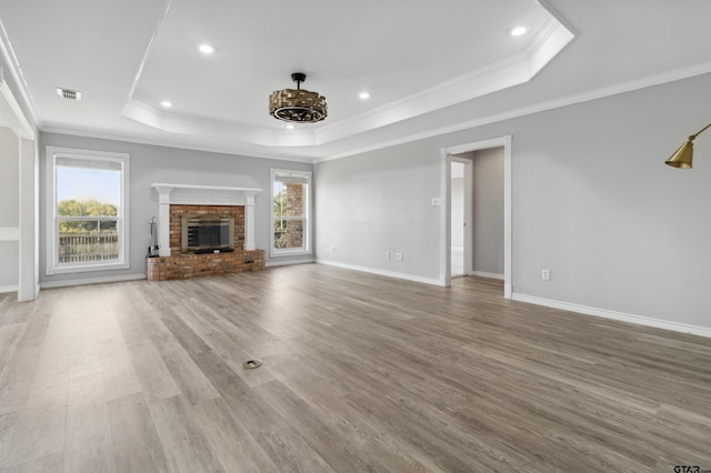 904 Van Winkle Cir, Athens, TX 75751 - unfurnished living room featuring a tray ceiling, plenty of natural light, ornamental molding, wood finished floors, and baseboards