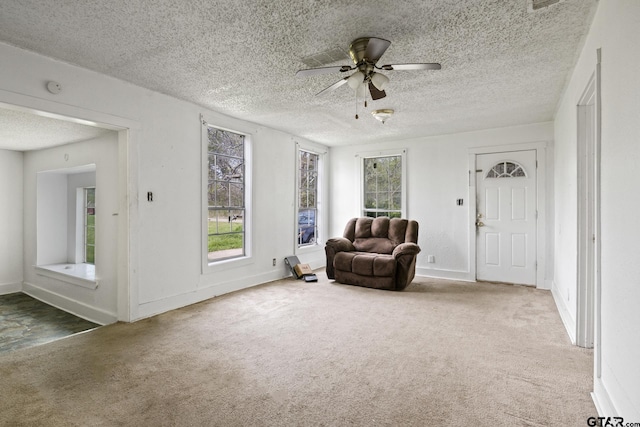 unfurnished room with a ceiling fan, carpet, baseboards, and a textured ceiling