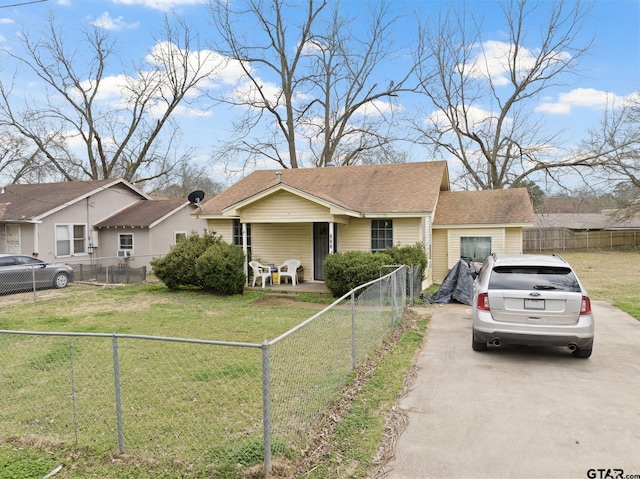 view of front of home with a front yard, concrete driveway, and a fenced front yard